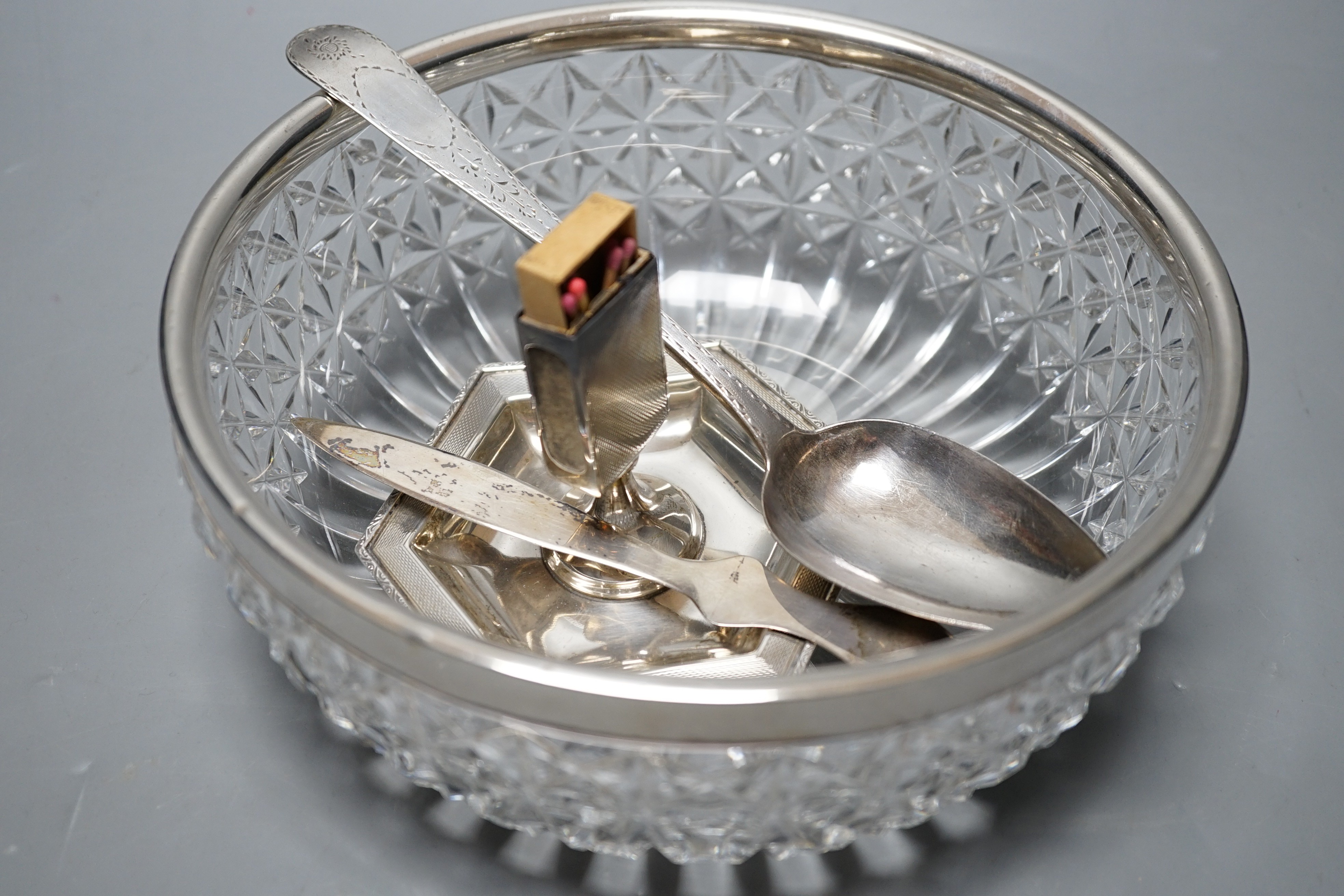 A George III Irish bright cut engraved silver tablespoon, Dublin, 1798, a silver match sleeve/ashtray, a silver rimmed fruit bowl fruit bowl and 925 letter opener.